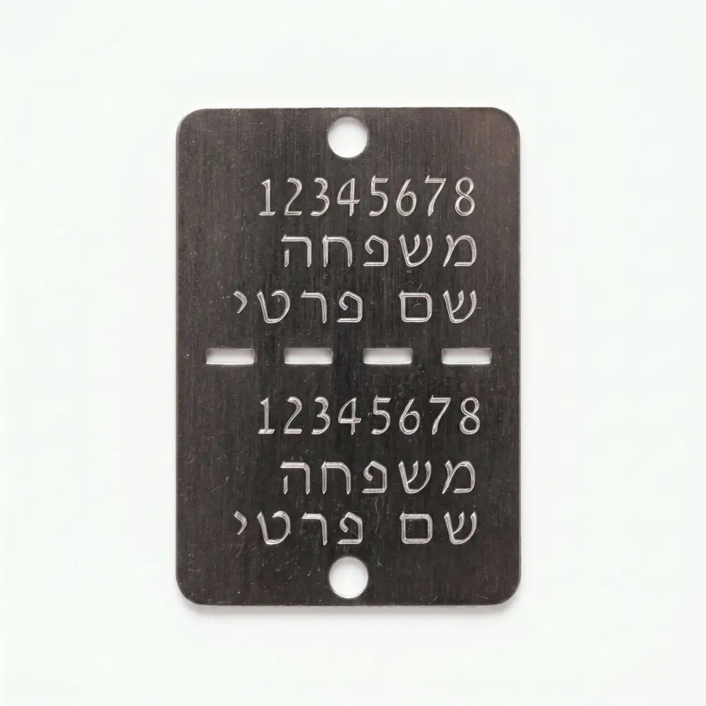 דיסקית צה’לית מתכתית כהה עם חריטה אישית בעברית ושני חורים למיגון או זיהוי לחיילים