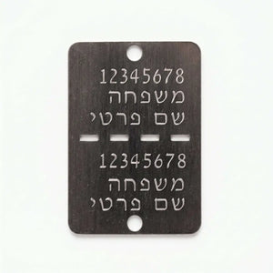 דיסקית צה’לית מתכתית כהה עם חריטה אישית בעברית ושני חורים למיגון או זיהוי לחיילים