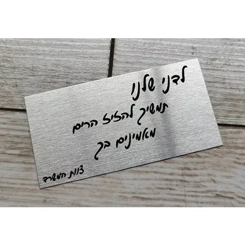 מגן כסף מלבני ממתכת עם כיתוב מעוגל בעברית לחשיבה מנצחת
