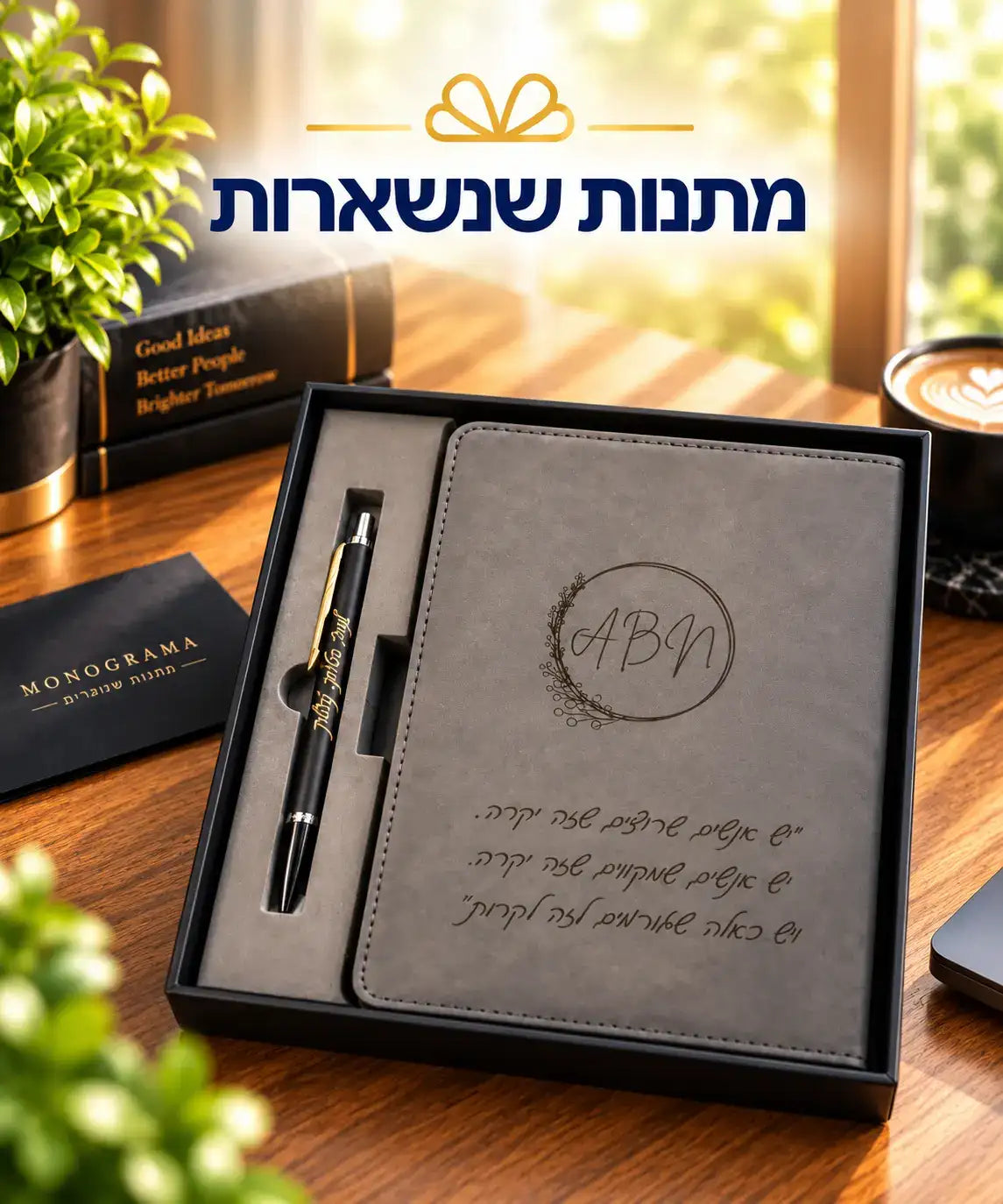 מחברת עור אפור בכריכה מהודקת עם מונוגרמה מוטבעת וכתב עברי, בליווי עט שחור עם נגיעות זהב.